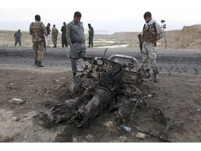 Afghan security forces gather at the site of Monday's suicide attack near the Bagram Air Base, north of Kabul, Afghanistan, Tuesday, April 9, 2019. Three American service members and a U.S. contractor were killed when their convoy hit a roadside bomb on Monday near the main U.S. base in Afghanistan, the U.S. forces said. The Taliban claimed responsibility for the attack.