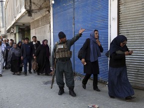 Staff of the Telecommunication Ministry are escorted after an attack outside the ministry building in Kabul, Afghanistan, Saturday, April 20, 2019. Afghan officials say an explosion has rocked the telecommunications ministry in the capital city of Kabul. Nasart Rahimi, a spokesman for the interior ministry, said Saturday the blast occurred during a shootout with security forces.