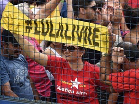 A woman holds a hashtag sign that reads in Portuguese "Free Lula" during a demonstration on the anniversary of the incarceration of former Brazilian President Luiz Inacio Lula da Silva, outside the jail where he is being held in Curitiba, Brazil, Sunday, April 7, 2019. While Da Silva serves a 12-year sentence for corruption and money laundering, he and his Worker's Party maintain his innocence, and claim persecution by political enemies to prevent him from running again for president.