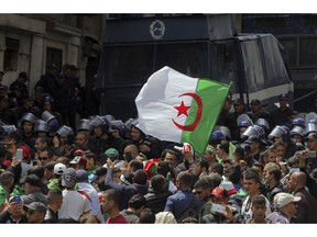 People face police officers as they protest against the country's leadership, in Algiers, Friday, April 12, 2019. The protest movement has been overwhelmingly peaceful but police were out in larger than usual numbers Friday and the atmosphere was strained.