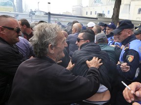 Albanian opposition supporters scuffle with police in front of the parliament building during a rally in Tirana, Wednesday, April 3, 2019. The opposition accuses the leftist Socialist Party government of Prime Minister Edi Rama of being corrupt and linked to organized crime, which the government denies.