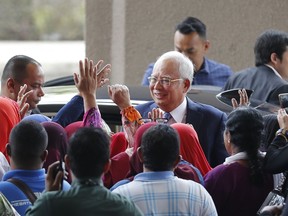 Former Malaysian Prime Minister Najib Razak, center, greets by supporters as he arrives Kuala Lumpur High Court in Kuala Lumpur, Malaysia, Wednesday, April 3, 2019. Najib Razak appeared in court Wednesday for the start of his corruption trial, exactly 10 years after he was first elected to office only to suffer a spectacular defeat last year on allegations he pilfered millions of dollars from a state investment fund.