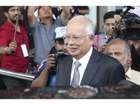 Malaysia's former Prime Minister Najib Razak, center, gets into a car after his court appearance at the Kuala Lumpur High Court in Kuala Lumpur, Malaysia, Monday, April 15, 2019. The corruption trial of Najib entered its second day, with a central bank official testifying that he has documents showing money from a company linked to a state investment fund was transferred into Najib's personal bank account.