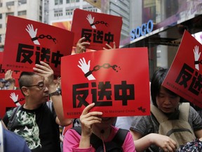 People raise placards reading " Against Extradition law" as thousands of protesters march along a downtown street against the extradition law in Hong Kong Sunday, April 28, 2019. Thousands of people protest to express their concerns about a proposed new extradition law that would make it possible for people to be sent to mainland China to face the justice system there.