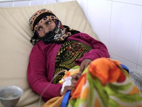 FILE - In this Thursday, March 28, 2019 file photo, an elderly woman is treated for suspected cholera infection at a hospital in Sanaa, Yemen. Cholera is surging once more in Yemen, with more than 76,000 suspected new cases and 195 deaths in March, double the number in the previous two months, according to U.N. figures. Doctors  point to the difficulty in controlling epidemics in a country where infrastructure has been decimated by four years of war.