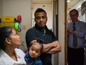 In this file photo taken on December 13, 2016 Supun Thilina Kellapatha and his partner Nadeeka holding their baby boy Danath, Sri Lankan refugees who helped shelter fugitive whistleblower Edward Snowden in 2013, speak as their lawyer Robert Tibbo listens in their flat in Hong Kong. The impoverished refugees living hand to mouth in the city took in the former National Security Agency contractor in 2013, helping him to evade authorities by hiding him in their cramped homes after he initiated one of the largest data leaks in U.S. history.