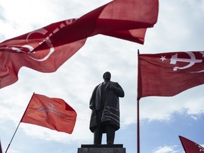 Supporters of the Ukrainian Communist Party wave red flags in front of a statue of the Soviet Union's founder, Vladimir Lenin, in the eastern Ukrainian city of Lugansk on April 22, 2014.