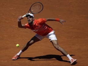 Novak Djokovic, of Serbia, returns the ball during his match against Jeremy Barty, of France, during the Madrid Open tennis tournament, in Madrid, Spain, Thursday, May 9, 2019.