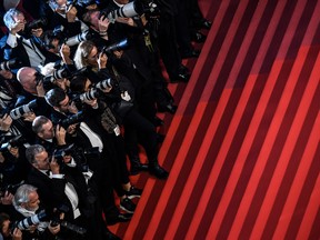 Photographers wait for cast members to leave the theatre following a screening.