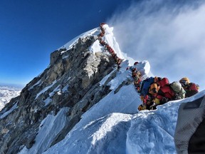 This handout photo taken on May 22, 2019 and released by climber Nirmal Purja's Project Possible expedition shows heavy traffic of mountain climbers lining up to stand at the summit of Mount Everest.