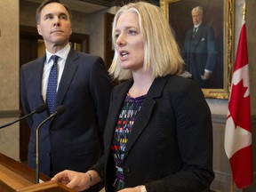 Minister of Finance Bill Morneau looks on as Minister of Environment and Climate Change Catherine McKenna speaks in the foyer of the House of Commons in Ottawa, Monday April 29, 2019.