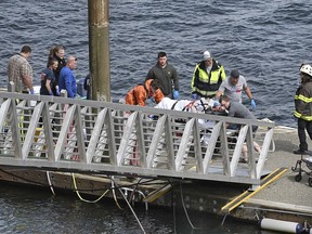 Emergency response crews transport an injured passenger to an ambulance at the George Inlet Lodge docks, Monday, May 13, 2019, in Ketchikan, Alaska. The passenger was from one of two sightseeing planes reported down in George Inlet early Monday afternoon and was dropped off by a U.S. Coast Guard 45-foot response boat.