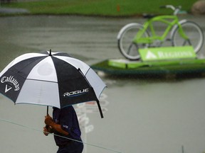 A golfer heads inside to shelter as play is suspended due to weather during the final round of the Regions Tradition Champions Tour golf tournament, Sunday, May 12, 2019, in Birmingham, Ala.