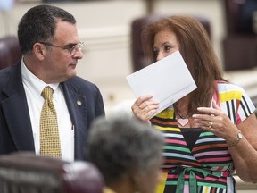 Rep. Terri Collins, right, chats with Rep. Chris Pringle on the house floor at the Alabama Statehouse in Montgomery, Ala., on Tuesday May 14, 2019. Alabama lawmakers are expected to vote on a proposal to outlaw almost all abortions in the state, a hardline measure that has splintered Republicans over its lack of an exception for pregnancies resulting from rape or incest. Rep. Collins is the sponsor of the bill.