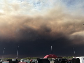 Smoke from a wildfire fills the sky above High Level, Alta. in a handout photo. Fire officials say winds continue to be favourable as crews battle a large wildfire burning a few kilometres from a northern Alberta town.THE CANADIAN PRESS/ HO-Stefanie Brown