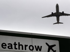 FILE - In this file photo dated Tuesday, June 5, 2018, a plane takes off over a road sign near Heathrow Airport in London. Campaigners fighting British government plans to expand Heathrow Airport have lost a challenge in one of the country's highest courts. A coalition of local councils, environmentalists and London residents claim the government has failed to properly address the impact on air quality, climate change, noise and congestion that adding a third runway would entail.