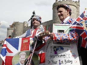 Royal fans John Loughery, left and Terry Hutt pose with flags and banners, outside Windsor Castle, in Windsor, south England, Tuesday, May 7, 2019, a day after Prince Harry announced that his wife Meghan, Duchess of Sussex, had given birth to a boy. The as-yet-unnamed baby arrived less than a year after Prince Harry wed Meghan Markle in a spectacular televised event on the grounds of Windsor Castle that was watched the world over.
