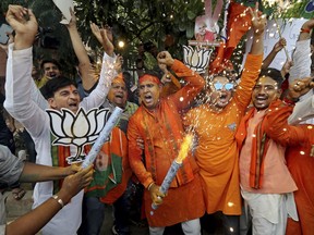 Bharatiya Janata Party (BJP) workers celebrate outside BJP headquarters in New Delhi India, Thursday, May 23, 2019. Indian Prime Minister Narendra Modi and his party have a commanding lead in early vote counting from the country's six-week general election.