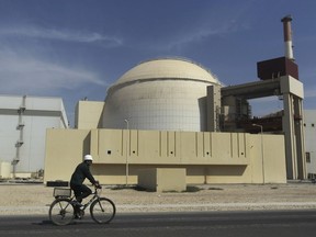 FILE - In this Oct. 26, 2010 file photo, a worker rides a bike in front of the reactor building of the Bushehr nuclear power plant, outside Bushehr, Iran. Iran's President Hassan Rouhani is reportedly set to announce ways the Islamic Republic will react to continued U.S. pressure after President Donald Trump pulled America from Tehran's nuclear deal with world powers. Iranian media say Rouhani is expected to deliver a nationwide address as soon as Wednesday, May 8, 2019, regarding the steps the country will take.