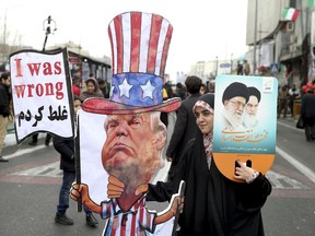 FILE - In a Feb. 11, 2019 file photo, an Iranian woman holds an effigy of US president Donald Trump, during a rally marking the 40th anniversary of the 1979 Islamic Revolution, in Tehran, Iran. Iranian President Hassan Rouhani is reportedly set to announce Wednesday, May 8, 2019, ways the Islamic Republic will react to continued U.S. pressure after President Donald Trump pulled America from Tehran's nuclear deal with world powers.