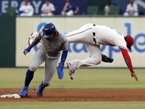 Kansas City Royals' Adalberto Mondesi steals second, upending Texas Rangers shortstop Elvis Andrus who was reaching for the throw during the fifth inning of a baseball game in Arlington, Texas, Friday, May 31, 2019.