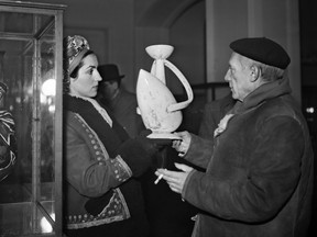 Spanish painter Pablo Picasso shows a pottery to his partner, Francoise Gilot, during an exhibition in Paris on Nov. 24, 1948.