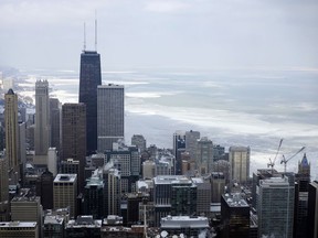 FILE - In this Feb. 17, 2015, file photo, ice covered Lake Michigan is seen behind downtown skyline, in Chicago. Big cities, like Chicago, aren't growing like they used to. New figures released by the U.S. Census Bureau on Thursday, May 23, 2019, show most of the nation's largest cities last year grew by a fraction of the numbers they did earlier this decade.