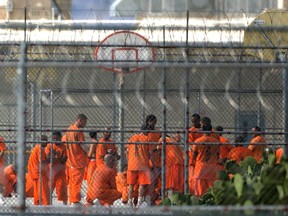 FILE - In this July 4, 2015, file photo, prison inmates stand in the yard at Arizona State Prison-Kingman in Golden Valley, Ariz. A book that discusses the impact of the criminal justice system on black men is being kept out of the hands of Arizona prison inmates. The American Civil Liberties Union is calling on the Arizona Department of Corrections to rescind a ban on "Chokehold: Policing Black Men."