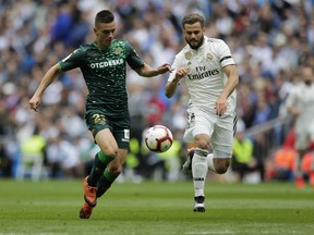 Betis player Lo Celso, left, duels for the ball against Real Madrid's Nacho Fernanzez during a Spanish La Liga soccer match at the Santiago Bernabeu stadium in Madrid, Spain, Sunday, May 19, 2019.