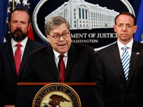 Attorney General William Barr speaks alongside Deputy Attorney General Rod Rosenstein, right, and acting Principal Associate Deputy Attorney General Edward O’Callaghan, left, about the release of a redacted version of special counsel Robert Mueller's report during a news conference, Thursday, April 18, 2019, at the Department of Justice in Washington.