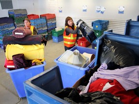 Kari Benhallack wheels a bin full of bolts of cloth as partner Barb Johnson-Hogue fills the sorting bins at the Goodwill Industries Donation Centre in Calgary, Alberta, on May 12, 2011. Medicine Hat police say officers and emergency medical personnel found the unconscious woman trapped in the opening of a bin early Monday morning.