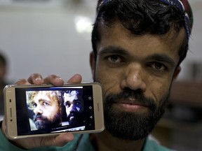 In this Friday, May 3, 2019 photo, Rozi Khan, a 26-year-old Pakistani shows his picture on his phone next to a picture of the U.S. actor Peter Dinklage who plays Tyrion Lannister on the TV series "Game of Thrones," in Rawalpindi, Pakistan. Khan does not only have a similar look, haircut and beard as Dinklage, but the two share a genetic condition that results in small stature.