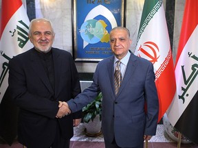Iraqi Foreign Minister Mohamed Alhakim, right, shakes hands with his visiting Iranian counterpart Mohammad Javad Zarif at the Ministry of Foreign Affairs Building in Baghdad, Iraq, Sunday, May 26, 2019.