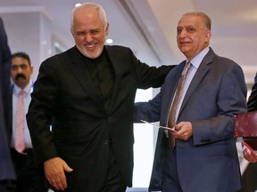 Iraqi Foreign Minister Mohamed Alhahkim, right, talks with his Iranian counterpart Mohammad Javad Zarif, after their press conference at the Ministry of Foreign Affairs in Baghdad, Iraq, Sunday, May 26, 2019.