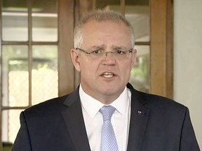 In this image made from video, Australia's Prime Minister Scott Morrison talks to media Friday, May 17, 2019, in Cairns, Australia. Morrison on Friday denied media reports that two Rwandan refugees resettled in Australia are suspects in the massacre of eight tourists in Uganda 20 years ago. (Pool via AP)