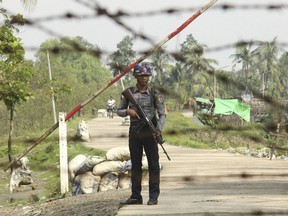 FILE - In this Sept. 6, 2017, file photo, a Myanmar police officer stands guard at a checkpoint in Shwe Zar village in the northern Rakhine state of Myanmar. Amnesty International, in a report issued Wednesday, May 29, 2019, says it has found new evidence of war crimes and human rights violations in Rakhine State, where the armed forces two years ago carried out a brutal counterinsurgency campaign that drove more than 700,000 members of the Muslim Rohingya minority to flee across the border to Bangladesh. (AP Photo/File)