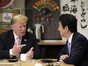 U.S. President Donald Trump, left, speaks with Japan's Prime Minister Shinzo Abe while sitting at a counter during a dinner at the Inakaya restaurant in the Roppongi district of Tokyo, Sunday, May 26, 2019.