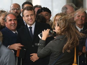 French President Emmanuel Macron poses for photos with supporters in Biarritz, southwestern France, Friday, May 17, 2019.