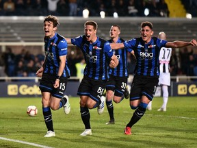Atalanta's Marten De Roon, left, celebrates with his teammates after scoring from the penalty spot his side's opening goal during the Serie A soccer match between Atalanta and Udinese at the Atleti Azzurri d'Italia stadium in Bergamo, Italy,  Monday, April 29, 2019.