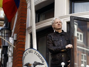 FILE - In this Friday, May 19, 2017 file photo, WikiLeaks founder Julian Assange looks out from the balcony while claiming political asylum at the Ecuadorian embassy in London.