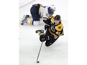 Boston Bruins' Danton Heinen (43) carries the puck in front of St. Louis Blues' David Perron (57) during the first period in Game 1 of the NHL hockey Stanley Cup Final, Monday, May 27, 2019, in Boston.