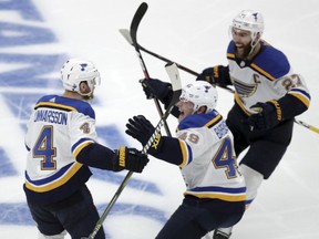 CORRECTS SOURCE AND PHOTOGRAPHER'S NAME - St. Louis Blues' Carl Gunnarsson (4), of Sweden, is congratulated by Ivan Barbashev (49), of Russia and Alex Pietrangelo, right, after he scored the winning goal against the Boston Bruins during the first overtime period in Game 2 of the NHL hockey Stanley Cup Final, Wednesday, May 29, 2019, in Boston.