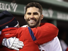 Boston Red Sox's J.D. Martinez gets a hug in the dugout after hitting a home run against the Colorado Rockies during the third inning of a baseball game Tuesday, May 14, 2019, at Fenway Park in Boston.