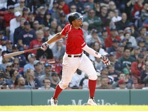 Boston Red Sox's Xander Bogaerts follows through on his RBI-double against the Houston Astros during the seventh inning of a baseball game Sunday, May 19, 2019, at Fenway Park in Boston.