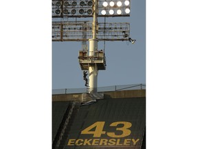 A technician climbs the left field lighting structure at the Oakland Coliseum in attempt to fix extinguished lights prior to the baseball game between the Cincinnati Reds and the Oakland Athletics on Tuesday, May 7, 2019, in Oakland, Calif. The game's start was delayed for work on the lights.