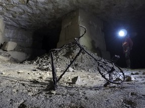 In this photo taken on Friday May 17, 2019, a childs bicycle quietly rusts in a quarry in Fleury-sur-Orne, near Caen, Normandy. Archeologists are making 3-D models of the network of tunnels that served as a bomb shelter for hundreds of civilians during the battle of Normandy that followed D-Day.