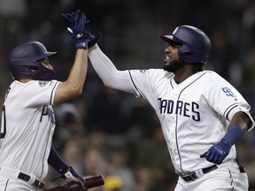 San Diego Padres' Franmil Reyes, right, is greeted by teammate Eric Hosmer after hitting a home run during the third inning of a baseball game against the New York Mets, Tuesday, May 7, 2019, in San Diego.