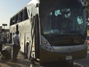Officials jack up a bus that was damaged by a bomb, in Cairo, Egypt, Sunday, March 19, 2019. Egyptian officials say a roadside bomb has hit a tourist bus near the Giza Pyramids. They said Sunday's blast wounded at least 17 people including tourists.
