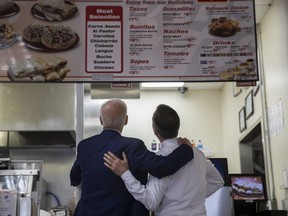 Former vice president and Democratic presidential candidate Joe Biden, left, and Los Angeles Mayor Eric Garcetti look at the menu at King Taco Wednesday, May 8, 2019, in Los Angeles.