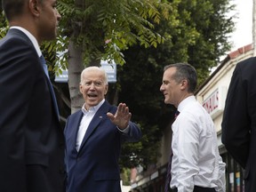 Former vice president and Democratic presidential candidate Joe Biden, left, waves toward members of the media as he and Los Angeles Mayor Eric Garcetti leave King Taco after talking to patrons Wednesday, May 8, 2019, in Los Angeles.